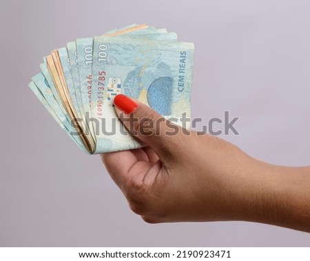 Hand holding money, six hundred reais, Brazilian currency, on white background. Royalty-Free Stock Photo #2190923471