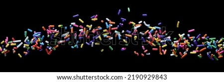 close-up sprinkle small colorful sugar candies flying. sweet food for toppings, donuts, and cakes at birthday celebrations. isolated on a black background Royalty-Free Stock Photo #2190929843
