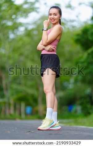 Portrait Asian women in sports outfits jog on running in park on spring summer day.Young fitness women run on park.  Sports and recreation healthy lifestyle concept