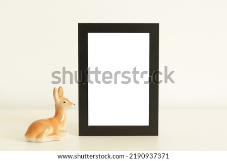 black old wooden frame and deer statue on white table