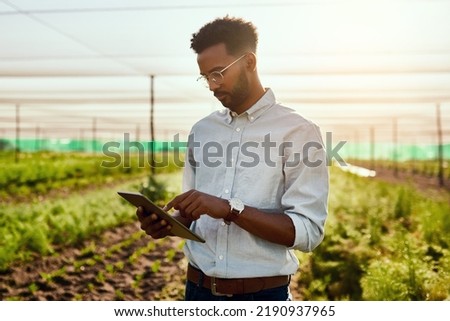 Male farmer planning online strategy on a tablet looking at farm growth outdoors. Digital agriculture analyst analyzing farming data. Worker research environment and sustainability Royalty-Free Stock Photo #2190937965