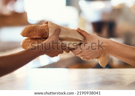Customer buying bread from bakery, purchasing baked goods and shopping for food at a shop. Hands of female client and employee giving service, taking product and helping with item at grocery store Royalty-Free Stock Photo #2190938041
