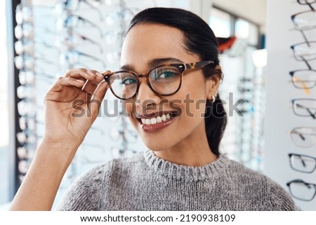 Woman wearing pair of trendy glasses, stylish spectacles and new prescription lenses at an optometrist. Portrait of a customer choosing, buying and shopping for frames for better vision and eyesight Royalty-Free Stock Photo #2190938109
