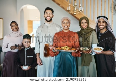 Smiling, festive muslim family celebrating eid or ramadan party lunch together holding dishes of food at home. Happy, traditional islamic religion group of friends enjoying cultural holiday Royalty-Free Stock Photo #2190938265