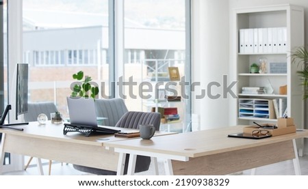 Clean, bright and empty home office interior organized with a computer and desk inside. Modern, contemporary and work space view of a decorated room with stylish decor and wooden furniture indoors Royalty-Free Stock Photo #2190938329