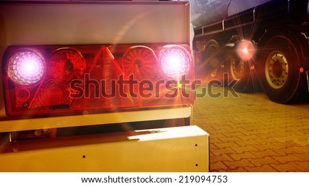 Glowing tail lights of parked truck in evening Royalty-Free Stock Photo #219094753