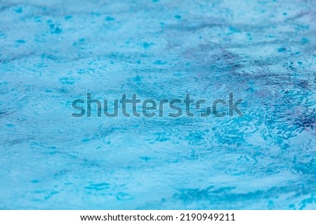 Surface of blue water in heavy rain. Background .