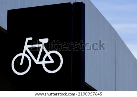 A black bicycle sign with a picture of white bike. Convenient infrastructure of big city streets. Parking area space for two-wheelers transport on the European street. Urban concept and ecology.