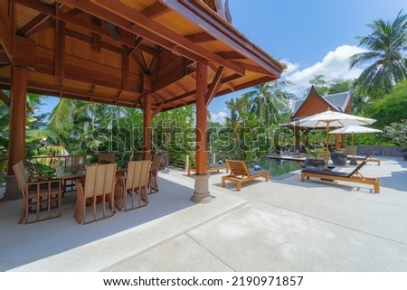 Beautiful luxury swimming pool with palm trees and sea view, Thai style decoration.