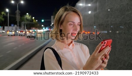 Beautiful Woman Standing, Using Smartphone on a City Street 