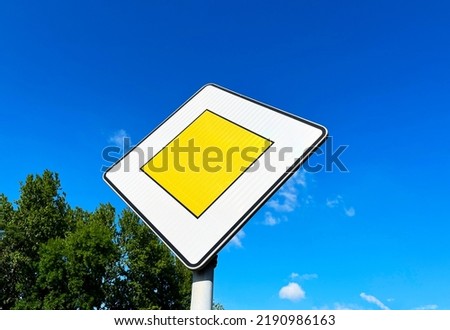 Road sign "Main road" on a blue sky background with copyspace