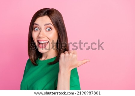 Photo portrait of cute young woman hand point copyspace suggest look banner dressed trendy green outfit isolated on pink color background
