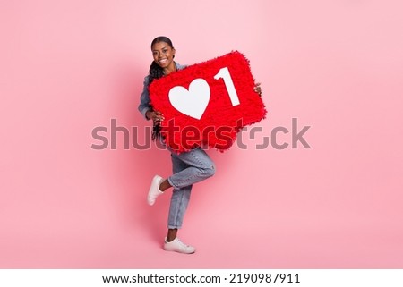 Full size photo of hipster carefree girl hold big pinata like reaction icon isolated on pink color background