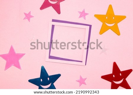 pink-purple frame as copy space on a pink background, colorful stars around the frame, creative art minimal concept