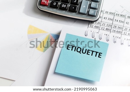 A card with the text ETIQUETTE is pasted on a notepad next to the table calculator and reports