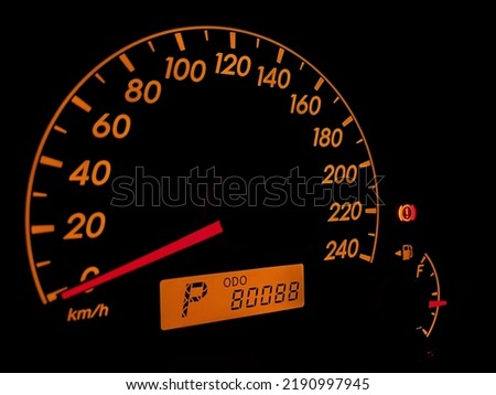Orange colored vehicle dashboard with 80088 km odometer. Close up speed odometer of stop car. Royalty-Free Stock Photo #2190997945