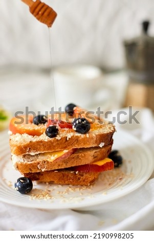 Breakfast on white bed sheets, good morning, summer french toast with cream cheese, honey, peaches and blueberries, coffee, flowers, Hotel room early morning, honeymoon