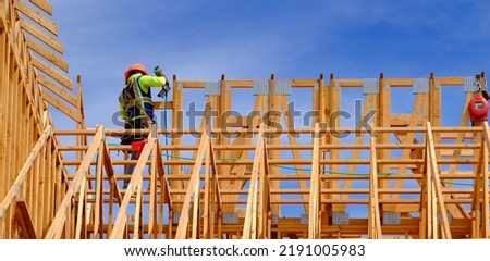 Construction workers working on new home or restidential building with wooden beams framed and sky Royalty-Free Stock Photo #2191005983