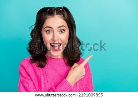 Closeup photo of young gorgeous cute girl wear pink sweater shock excited finger pointing empty space advert isolated on cyan color background