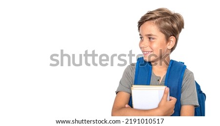 Smiling boy looks at the side with books and blue backpack isolated on white background. Back to school