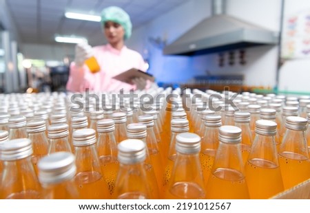 Product quality control staff at the fruit juice production line Perform product quality checks To ensure that the products produced are of good quality before being delivered to consumers further Royalty-Free Stock Photo #2191012567