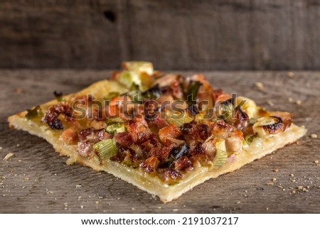 Slice of homemade pizza with bacon and green onion on wooden background