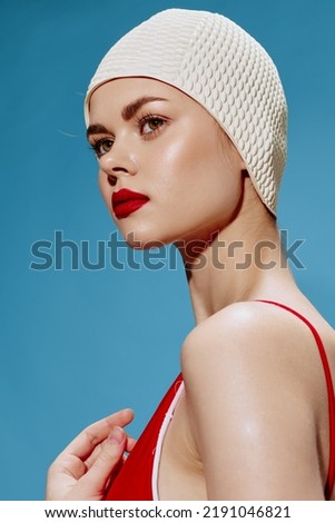 Conceptual revival of retro art. Close-up shot of a lady in a swimming cap on a blue background looking into the distance Royalty-Free Stock Photo #2191046821