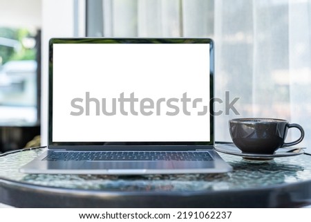 Mockup of laptop computer with empty screen with coffee cup and smartphone on table of the coffee shop outdoor background,White screen Royalty-Free Stock Photo #2191062237