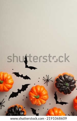 Halloween concept. Top view vertical photo of pumpkins spiders bat silhouettes and black confetti on isolated grey background with empty space