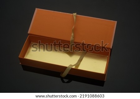 Traditional gift box with gold ribbon. Useful for wedding gifts, greetings boxes, celebration boxes, and sweet boxes. Seamless Black Color Background.