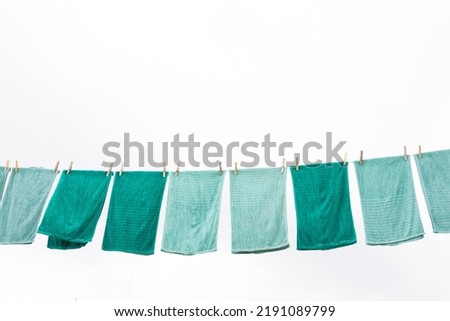 Blue and green towels hanging and drying after washing, with a clean and clear sky Royalty-Free Stock Photo #2191089799