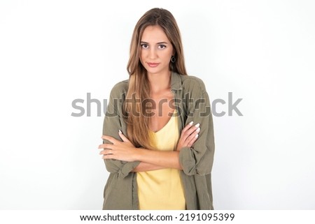 young beautiful woman wearing green overshirt over white background Pointing down with fingers showing advertisement, surprised face and open mouth