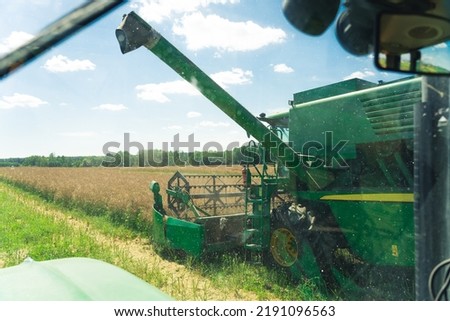 green combine harvester working in the field. High quality photo
