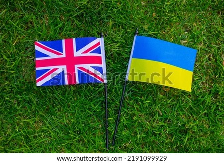 close up of Great Britain and Ukraine flags on green grass. national symbol of the country