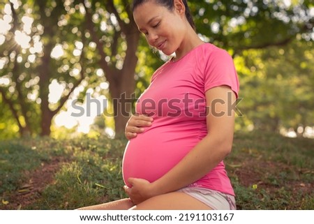 A pregnant mother relaxing outdoor. Maternity wellness.