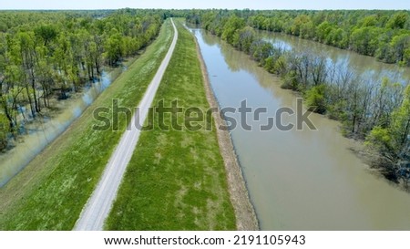 Mississippi River levee near Eagle Lake. Flood water receding from the levee. Birds wading along the edge. Royalty-Free Stock Photo #2191105943