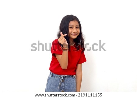 Asian little girl standing with love shape hand gesture. Isolated on white background