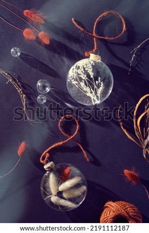 Autumn flat lay with dry grass in glass trinkets, hemp cord, fuchsia, magenta, red dried bunny tails and oak leaves. Dark purple paper background, top view, flat pay from above. Royalty-Free Stock Photo #2191112187