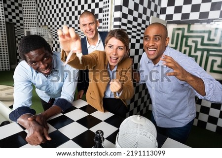 Four friends of different nationalities solving puzzles in quest room Royalty-Free Stock Photo #2191113099