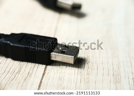 Macro shot of USB cable on wooden table. Modern technology concept. Selective focus