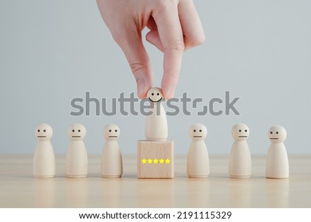 Hand pick happy face wooden figure. Customer service rating experience and feedback emotion and satisfaction survey. Human Resources management choosing positive attitude to team. Royalty-Free Stock Photo #2191115329