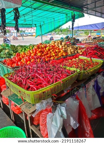 a picture of a traditional market in maros that looks like a pile of fresh chilies and tomatoes