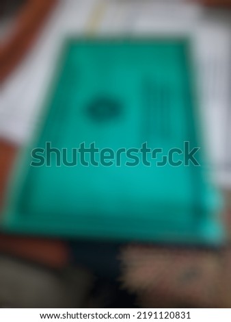 Defocused or blurred abstract background of a green journal for teacher placed on the desk
