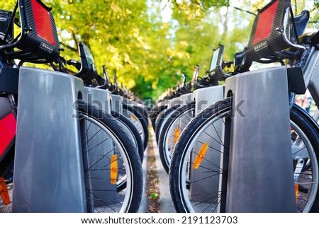 Electric bike share bicycles in a row at rental service parking lot on city street. Shared transport service can provide urban residents with convenient time-saving travel mode and protect environment Royalty-Free Stock Photo #2191123703