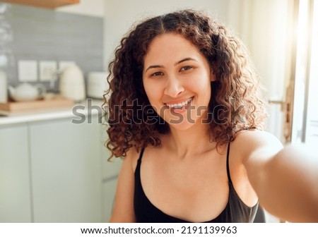 Fun, happy and stylish woman taking a selfie for social media, dating app and online blog while relaxing at home. Portrait of relaxed lady on video chat, filming livestream or blogging from kitchen