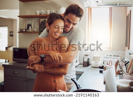 Love, romance and fun couple hugging, cooking in a kitchen and sharing an intimate moment. Romantic boyfriend and girlfriend embracing, enjoying their relationship and being carefree together Royalty-Free Stock Photo #2191140163