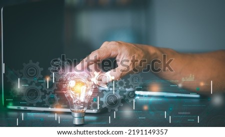 Businessman pointing to a fluorescent lamp representing creative discovery and inspiration through imagination, innovative ideas and inventions developed through planning and brainstorming. Royalty-Free Stock Photo #2191149357