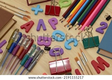 letters books pencils fountain pens brushes stationery clips on the table concept education business science. High quality photo