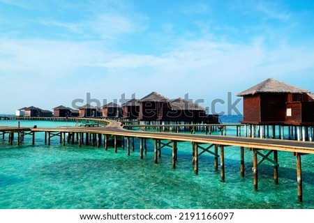 A tropical resort nestled at the south end of the Maldives in the heart of the Indian Ocean, picturing an array of overwater villas.