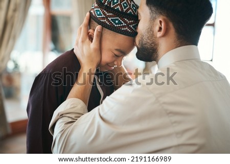 Muslim father, parent or man kissing his son on the forehead, bonding and showing affection at home. Happy, smiling and Arab boy embracing, celebrating traditional holiday and being peaceful  Royalty-Free Stock Photo #2191166989
